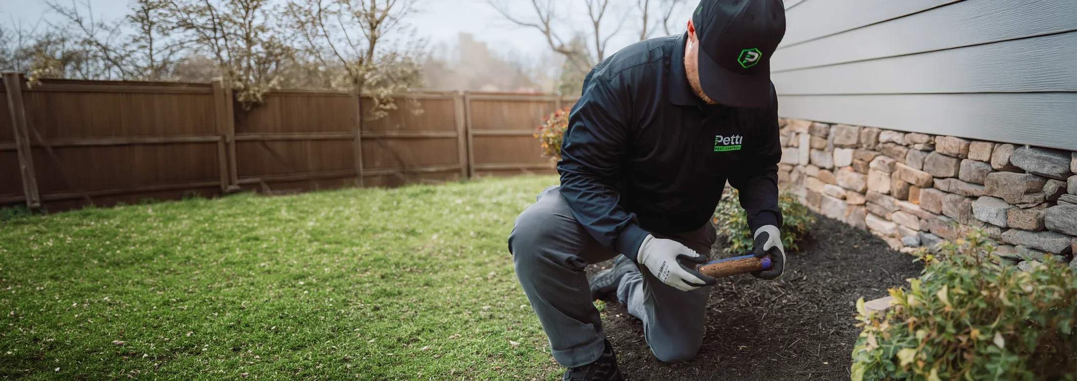 technician checking termite bait station
