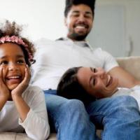 family sitting on couch laughing together