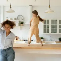 mother and daughter dancing in kitchen