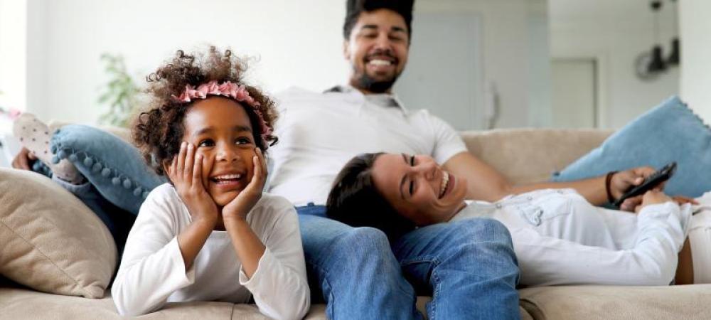 family sitting on couch laughing together