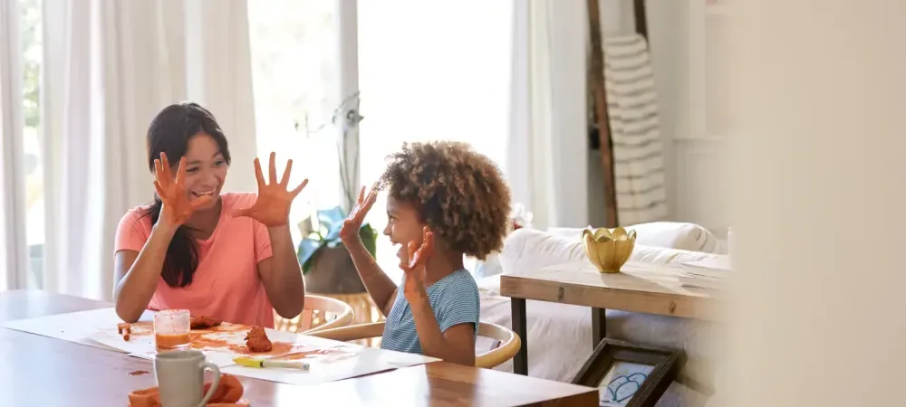 mother and daughter laughing at table