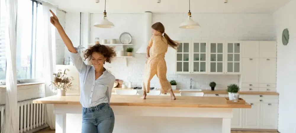 mother and daughter dancing in kitchen