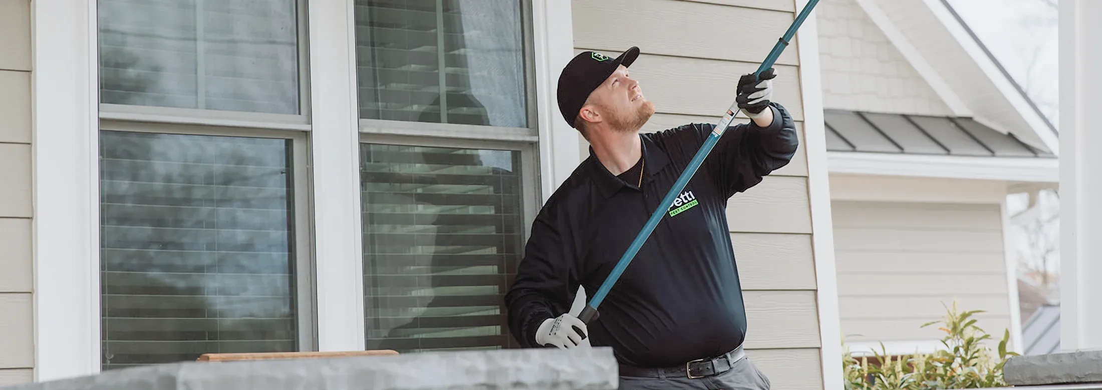 technician sweeping exterior of home