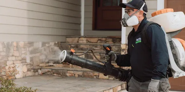 Technician spraying for mosquitoes